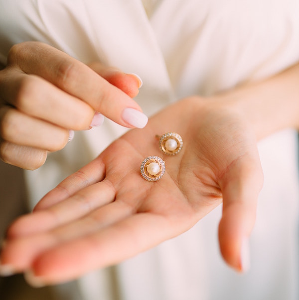 a woman holds a pair of expensive earrings